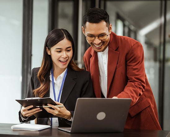 A man and woman looking at a laptop