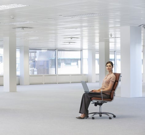 A woman sitting in an office chair with a laptop